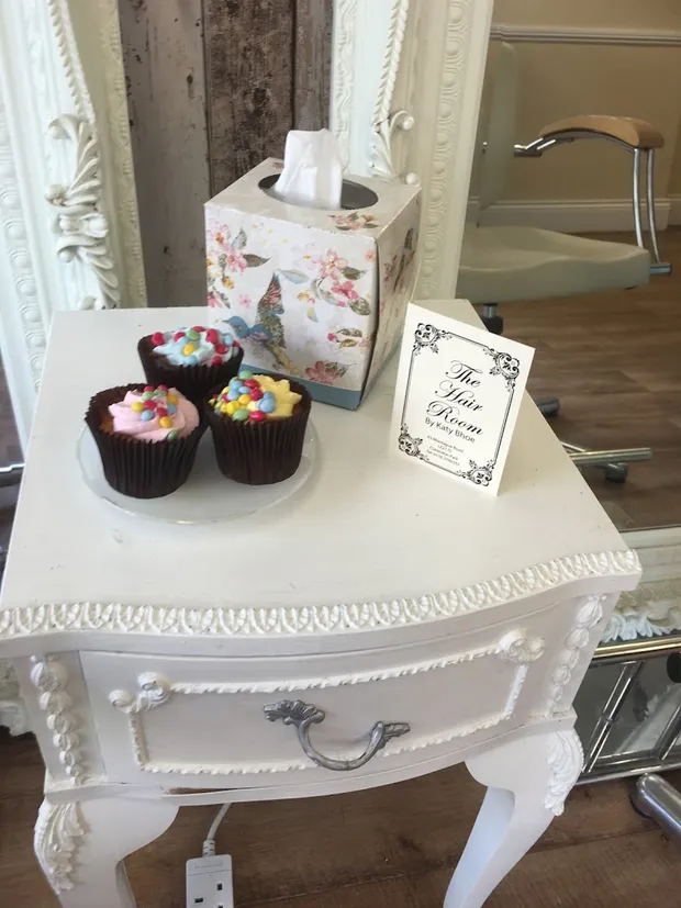 A vintage console with cupcakes and a Hair Room card